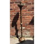 A tall brass church candlestick with spiralled body, raised on circular spreading foot, 160cm