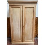 A Victorian stripped pine two door wardrobe, the doors enclosing hanging space, drawers and