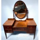 An Edwardian dressing table with central oval mirror, central drawer flanked to two small drawers