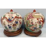 A pair of Chinese porcelain globular ginger jars and covers, painted in polychrome enamel with