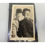 An autograph book containing a signed sepia photo of Stan Laurel and Oliver Hardy wearing bowler