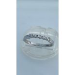 An 18ct white gold diamond ring, set with 5 x small round brilliant cut diamonds, total diamond