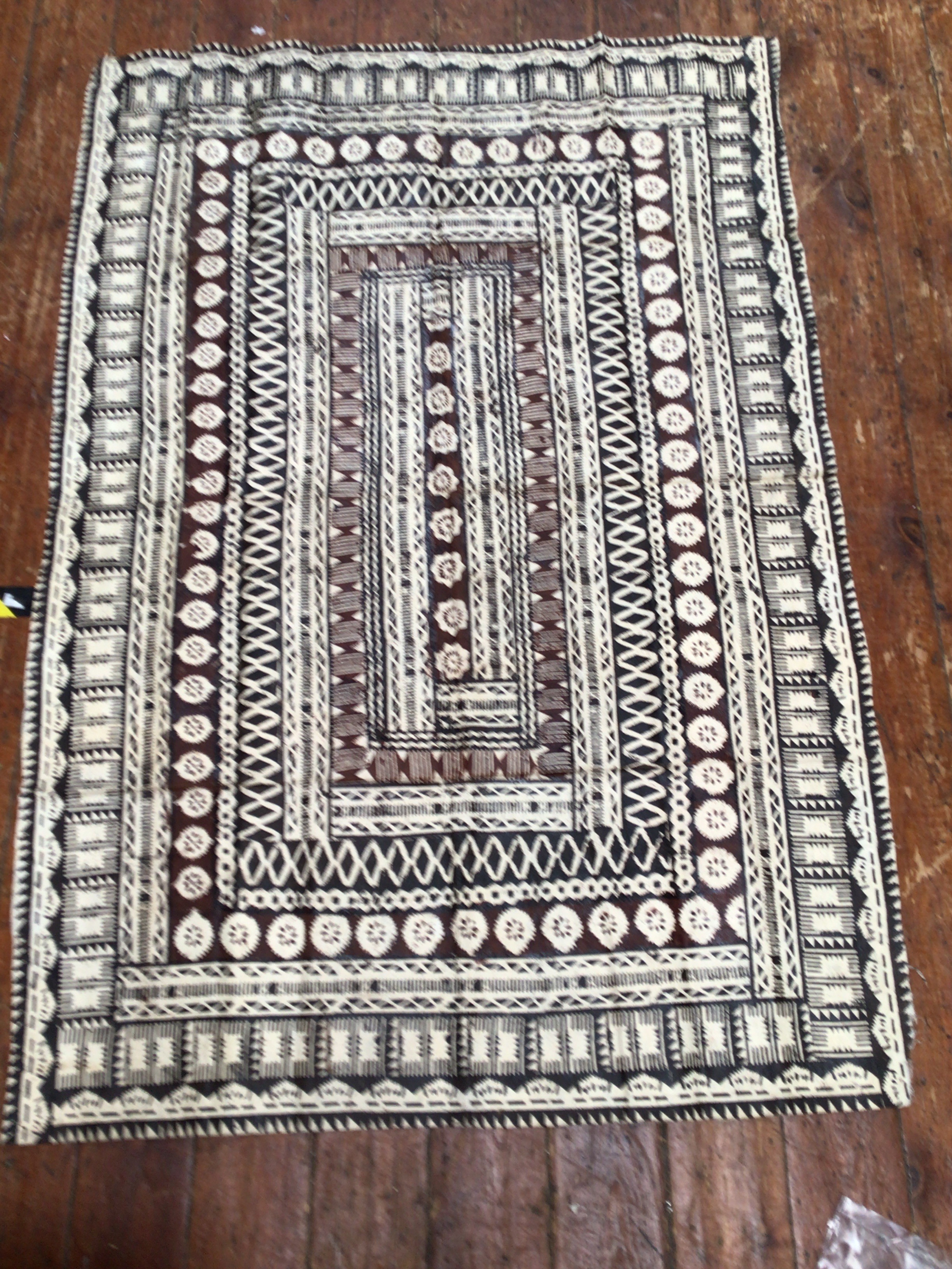 A large Pacific Islands Tapa bark cloth painted with geometric black and brown shapes, 180 x 125cm