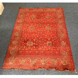 Four various hand knotted rugs including a red, cream and blue rug with geometric design and a