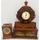 A hexagonal clock with two-tier stepped base, inlaid with brass flowers, foliage and charging