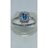 A 9ct white gold dress ring, set with an emerald cut tanzanite to the centre, with small diamonds