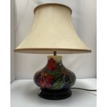 A Moorcroft Pottery lamp, in the Simeon pattern, of compressed, globular form, raised on stepped,