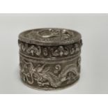 A Chinese silver pill/spice pot and cover, of circular form, the sides and lid with repoussé