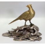 A Chinese gilt figure of a pheasant looking over its right wing, perched on a silvered
