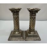 A pair of silver candlesticks modelled as corinthian columns with detachable sconces, spiralled