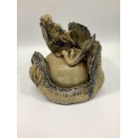 A 19th century Japanese glazed clay figure of a dragon with its body wrapped round a pearl or
