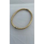 Addendum 14ct not 9ct gold, a hollow hinged bangle, in a rope twist design with safety catch, weigh