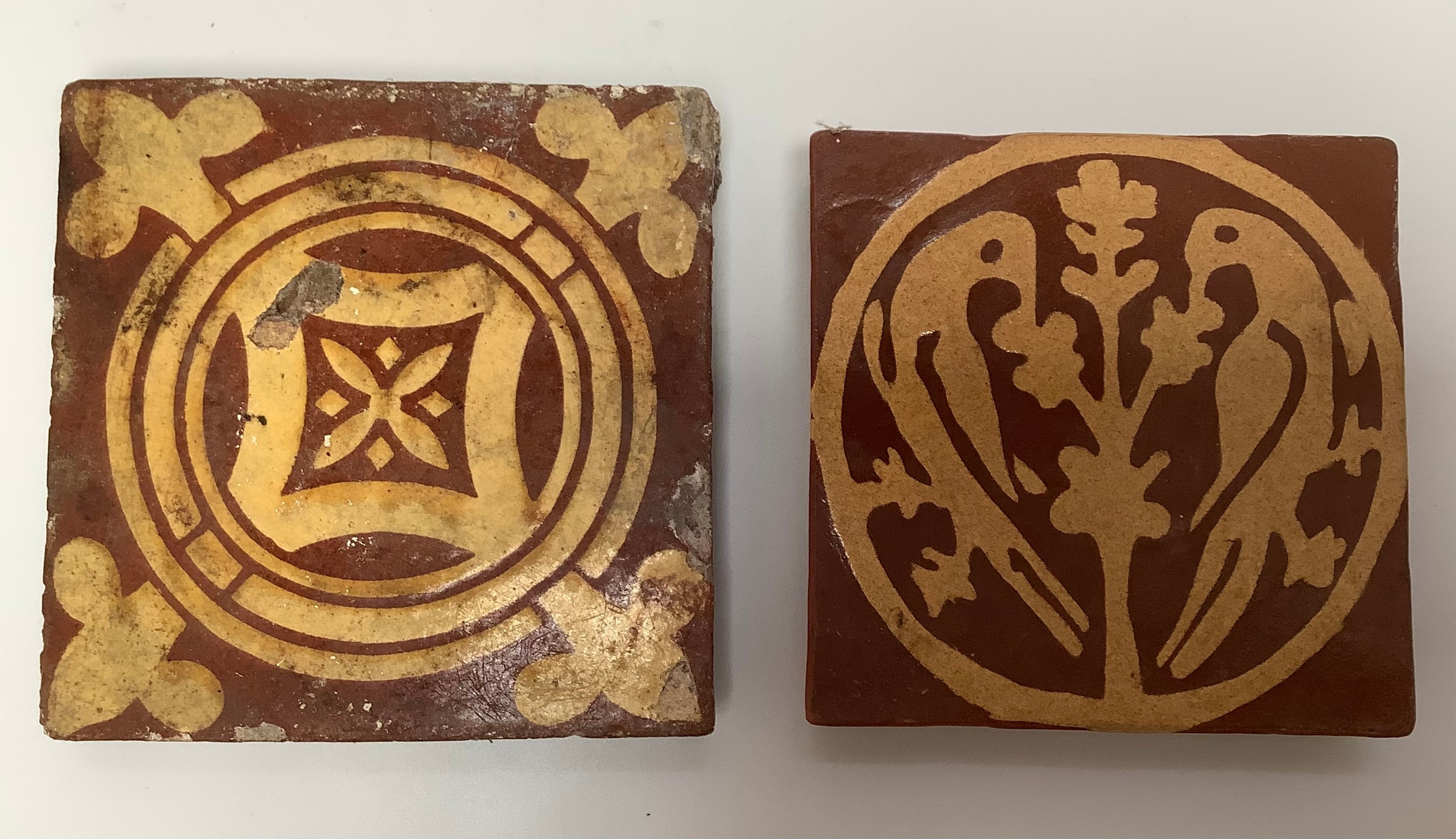 A medieval encaustic tile c.14th/15th century, decorated in cream slip with stylised fleur-de-lis