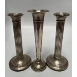 A pair of silver candlesticks with reeded columns and loaded circular bases, 18cm high, together