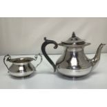 A small silver teapot with beaded foliate rim and ebonised handle, together with a matching twin-