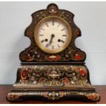 A 19th century black lacquered mantel clock, scalloped shaped case with floral brass, mother of