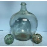 Two green glass fishing floats, one with netting, together with a green glass carboy (af) (3)