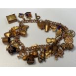 A ladies 9ct gold charm bracelet, with approximately 35x charms 50.0g