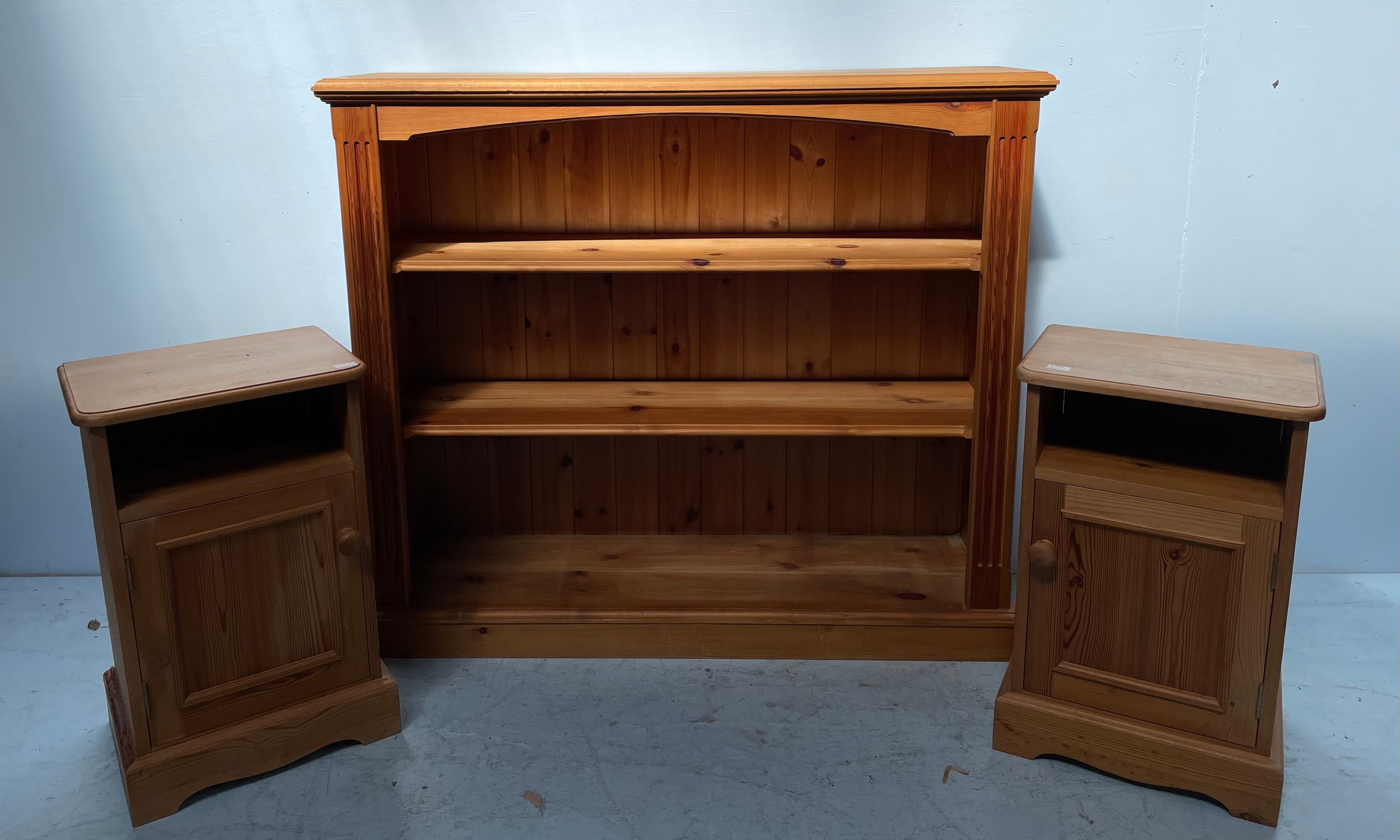 A modern pine bookcase with two adjustable shelves, fluted sides, 120cm wide, together with a pair