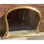 A gilt framed. over-mantel mirror with arched top and shaped sides, 130cm wide