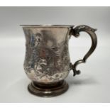 A silver christening tankard, embossed with flowers and central cartouche engraved with crest,