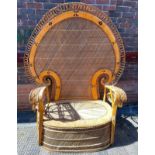A very large ornate rattan and cane Peacock settee / chair, with semi-circle back and curved arms,