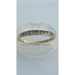 A 9ct yellow gold eternity ring, set with 12 x small round diamonds in a channel setting, total