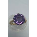 A 14ct yellow gold dress ring, set with round purple coloured faceted stone, ring weighs 3.9