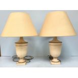 A pair of Laura Ashley cream and gold ‘antiqued’ urn shaped lamps with cream shades (not tested)