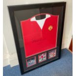 A framed replica 1972/74 Manchester United shirt, signed by the club’s third all-time top goalscorer