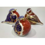 Three Royal Crown Derby paperweights modelled as birds, including two Robins, all with printed