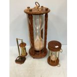A very large hourglass sand timer in mahogany frame with circular top and bottom, supported by