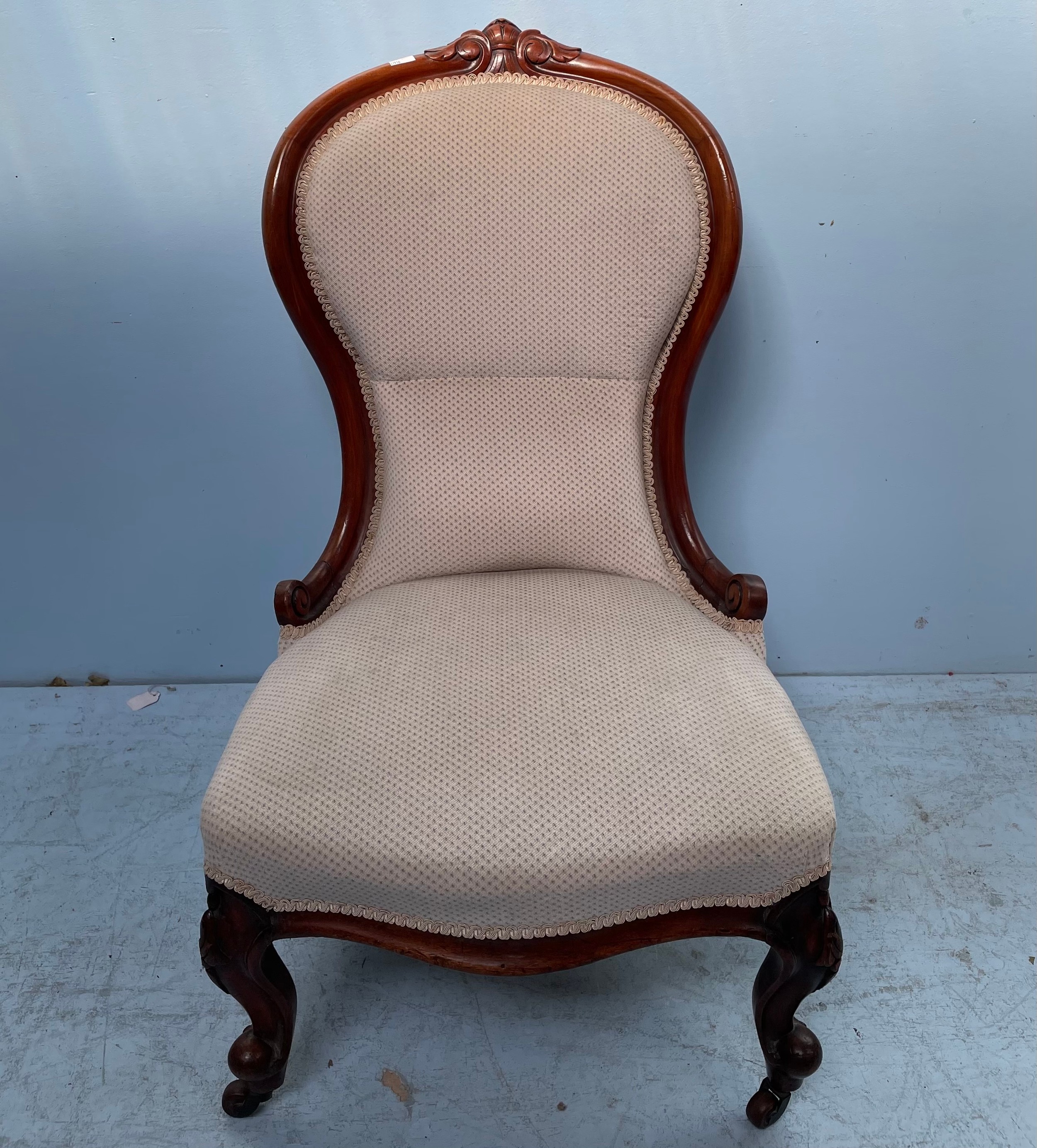 A Victorian stained walnut spoon-back nursing chair with stuff-over upholstery