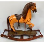 A carved and painted wooden ornamental rocking horse, possibly a pull along with later metal