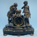 A bronze figural mantel clock modelled with two musicians, the man holding a birds nest with two