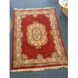 A large Oriental Eastern Kayam rug with central cream, green and brown floral medallion to red