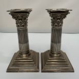 A pair of Victorian silver candlesticks modelled as corinthian columns with detachable beaded