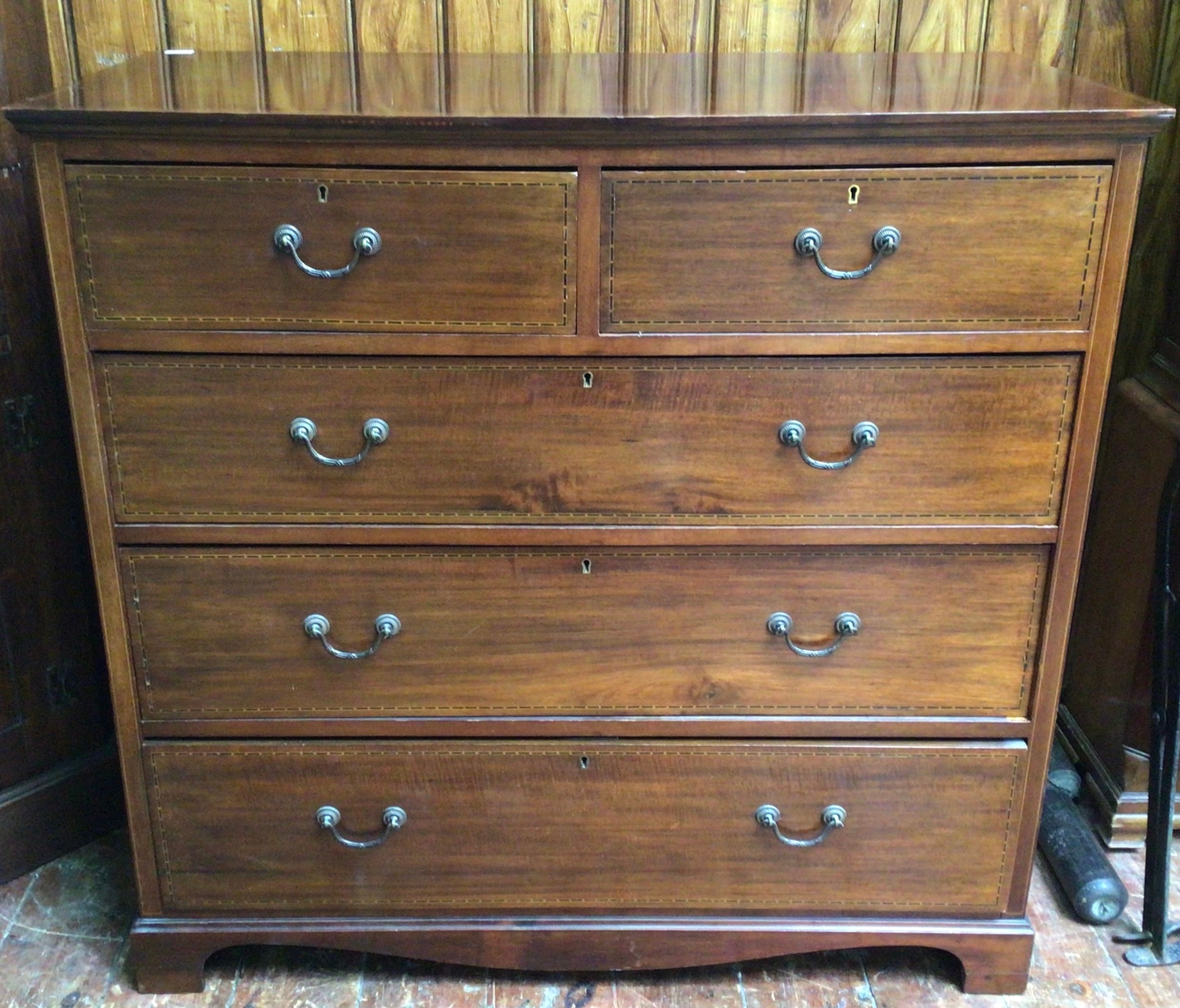 An Edwardian inlaid mahogany chest of drawers with two short and three long graduated drawers,