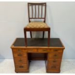 A faded walnut campaign desk with black leather top, two drawers above two banks of three