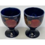 A pair of Moorcroft 'Pomegranate' pattern eggcups, each with impressed Moorcroft mark, 6cm high