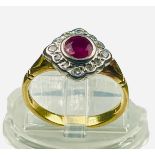 An 18ct yellow gold dress ring, set with a round faceted ruby to the centre, and 12 x small round