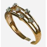 A 9ct rose gold ring, with seven small diamonds in heart shape settings, in a three wire bar design,