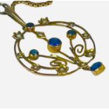 A circular yellow metal pendant, set with blue stones and seed pearls, suspended on a 9ct yellow and