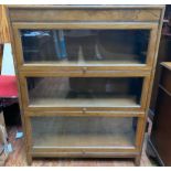 An early 20th century oak three tier sectional bookcase by Gunn, with three up-and-over graduated