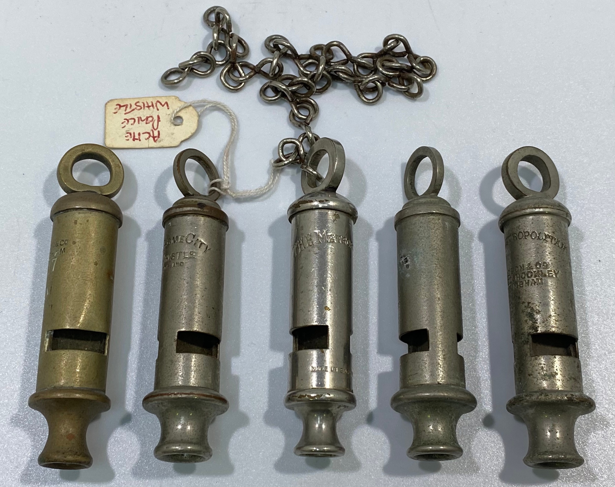 Five various whistles including a WW1 Huddson No.1 dated 1917 with broad arrow, ACME City, ARP and