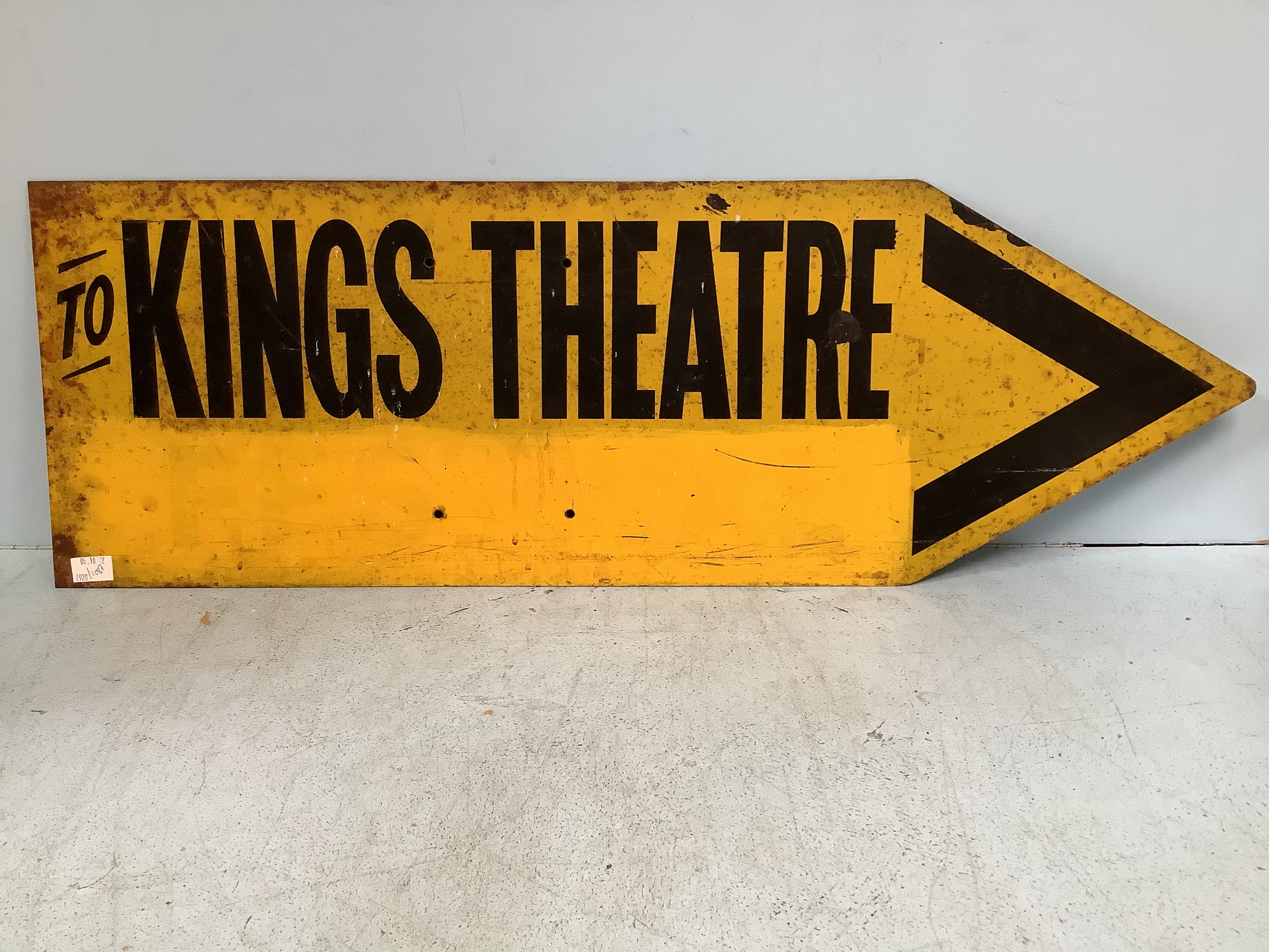 An enamel sign shaped as an arrow and reading ‘To Kings Theatre’, finished in yellow and black,