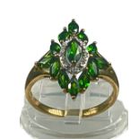 A 9ct yellow gold dress ring, set with green peridots and diamonds in an elongated cluster design,