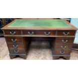 A mahogany kneehole desk with gilt tooled green leather scribe, central frieze drawer flanked by two