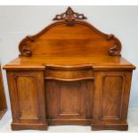 A 19th century walnut three-door inverted break-front chiffonier, raised back with carved