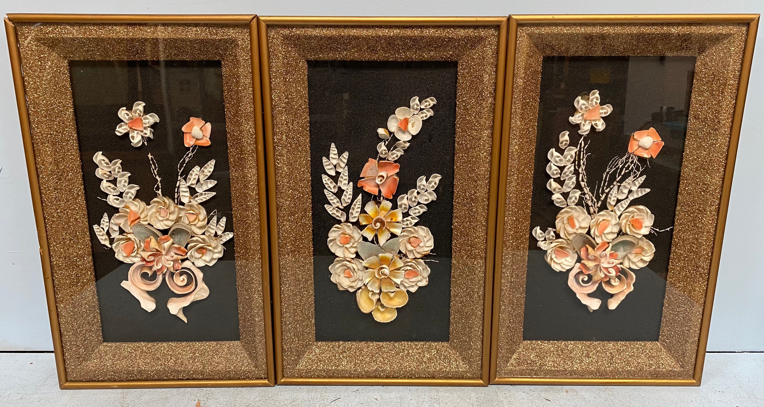 A set of three shell work / sailors valentine style floral dioramas, sand encrusted mounts, glazed